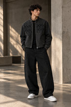 Model wearing the HLY WTR black denim jacket with tonal HW monogram chest design and black wide-leg pants.