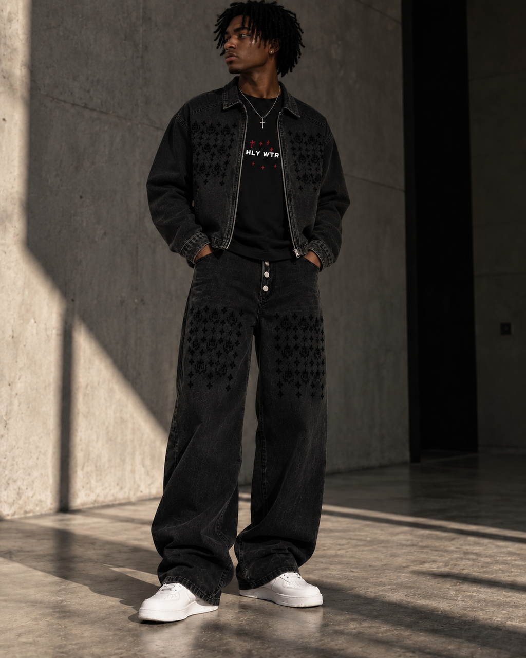 Model wearing the HLY WTR Heritage Monogram black denim jacket and wide-leg jeans with tonal HW pattern details