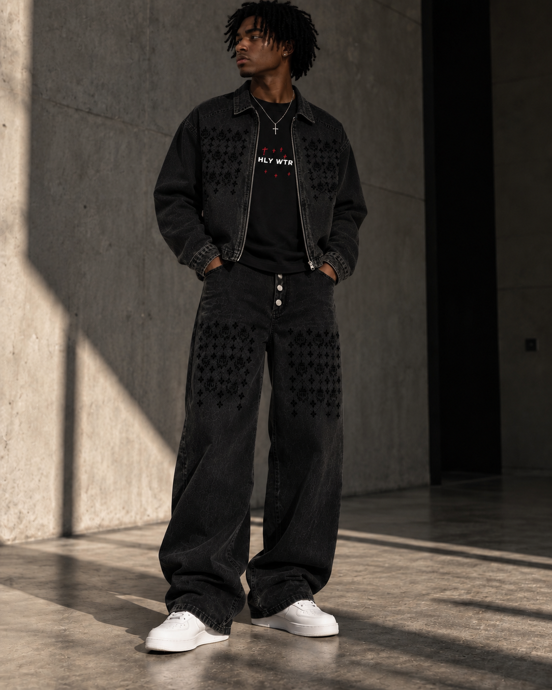 Model wearing the HLY WTR Heritage Monogram black denim jacket and wide-leg jeans with tonal HW pattern details
