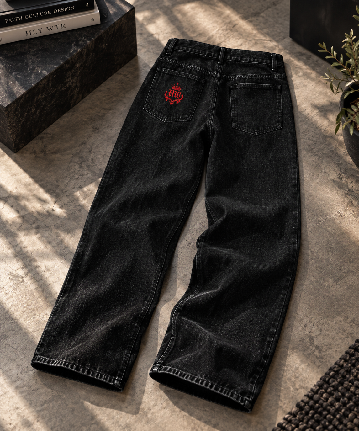 Back view of HLY WTR Heritage Monogram black wide-leg jeans featuring a red HW crown crest on the back pocket.